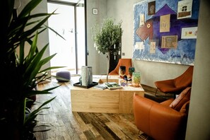 A modern living room with a wooden desk, orange leather chair, and a large abstract painting on the wall. - Benci House (Florence)