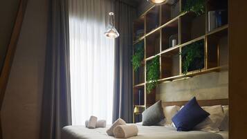 A bedroom with a wooden bed, a bookshelf, and a window with curtains.