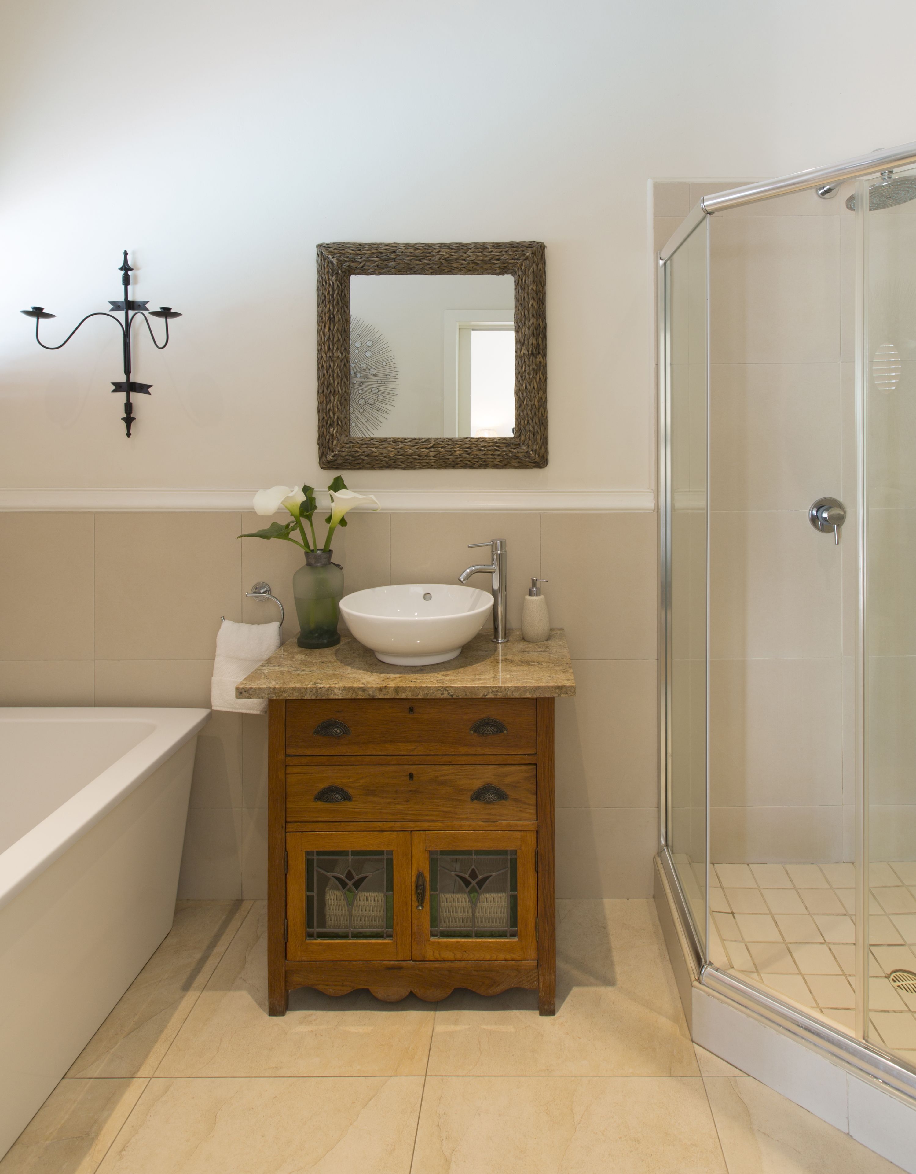 Un baño con bañera, lavamanos, espejo y ducha.