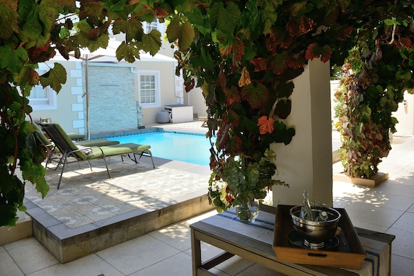 Una piscina al aire libre, sillones reclinables de piscina