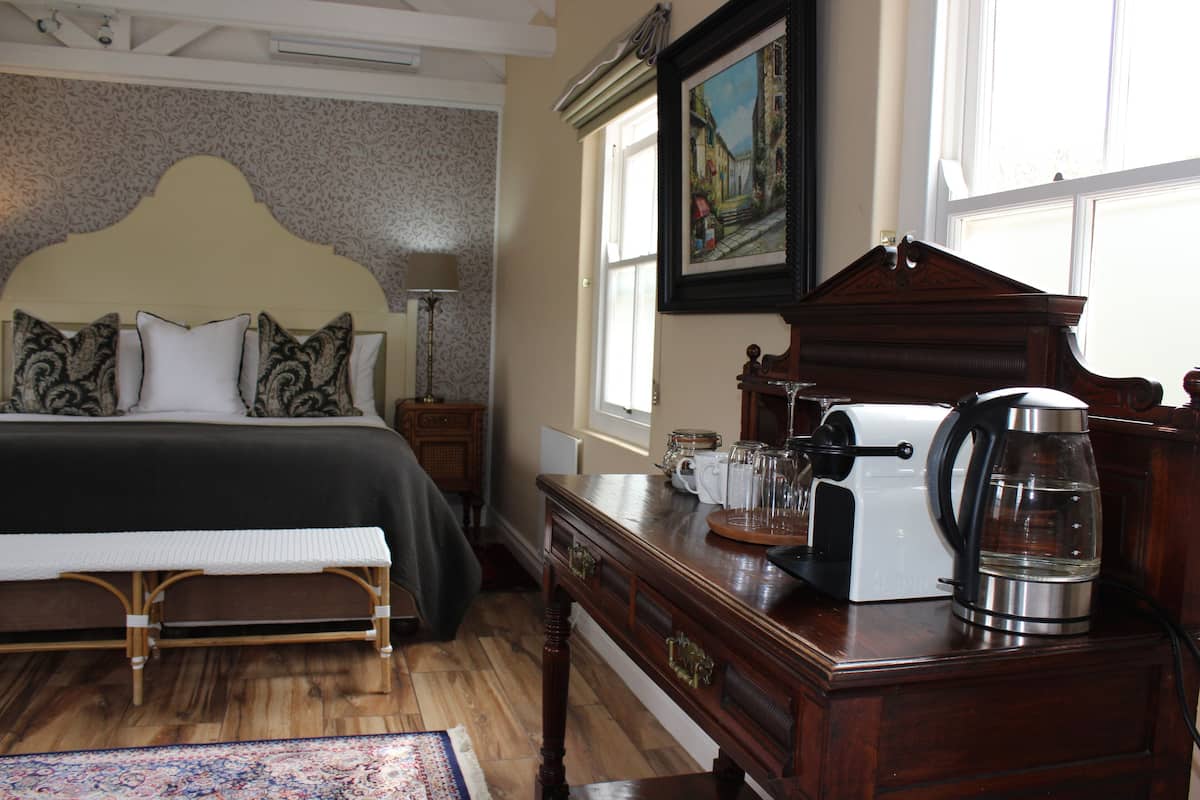 A bedroom with a bed, bedside table, and a coffee maker.