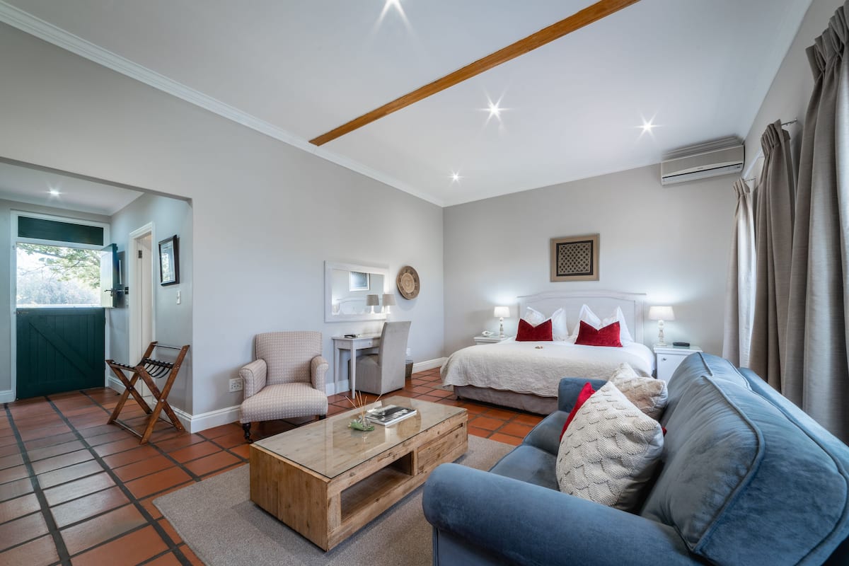 Un dormitorio moderno con cama, mesita de noche y escritorio con silla.