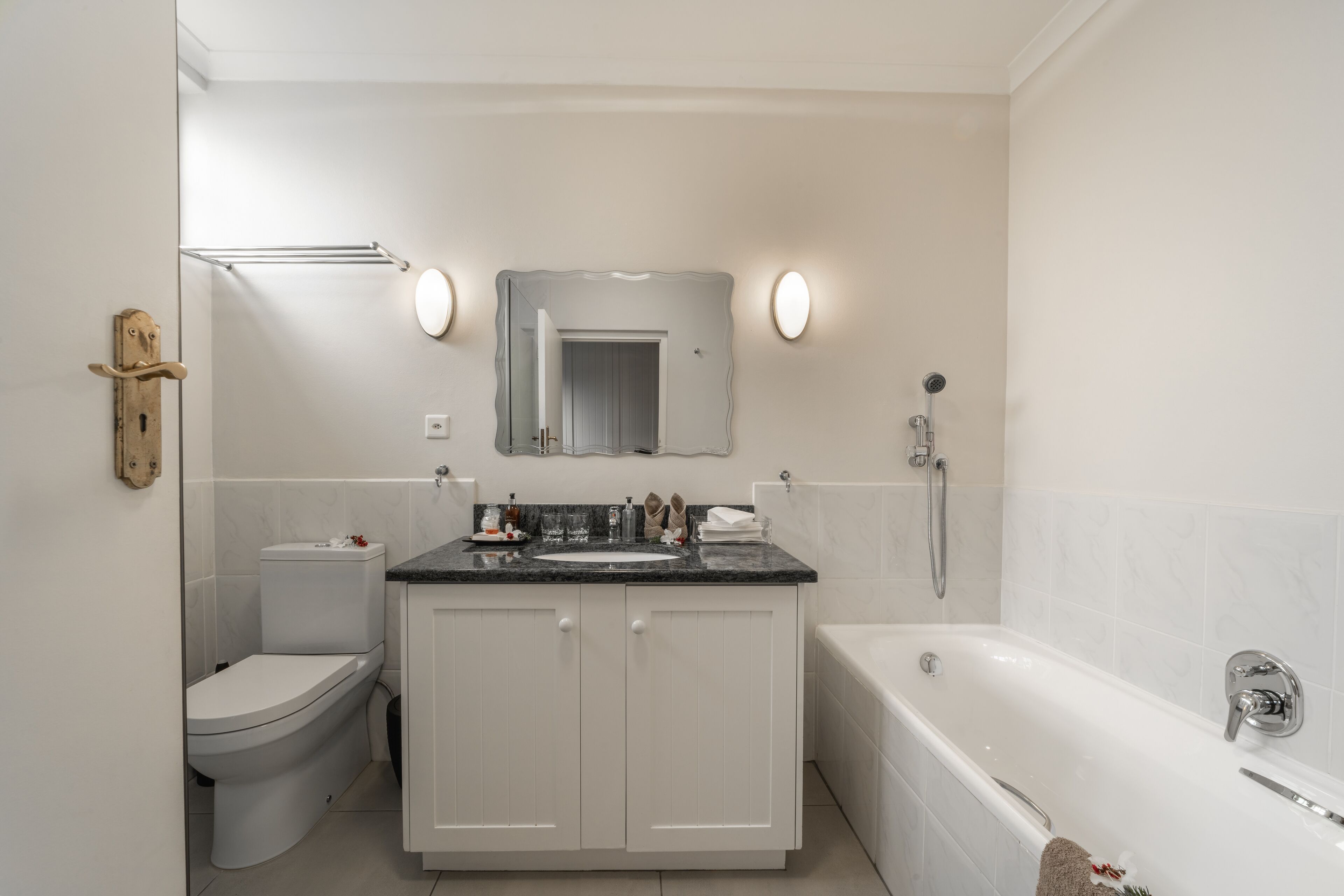 A modern bathroom with a toilet, sink, vanity, and bathtub.