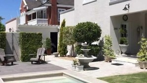 A modern house with a swimming pool, outdoor seating, and well-maintained landscaping.