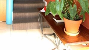 A staircase leading to a landing with a potted plant on the landing. - Broadway Tygervalley (Cape Town)