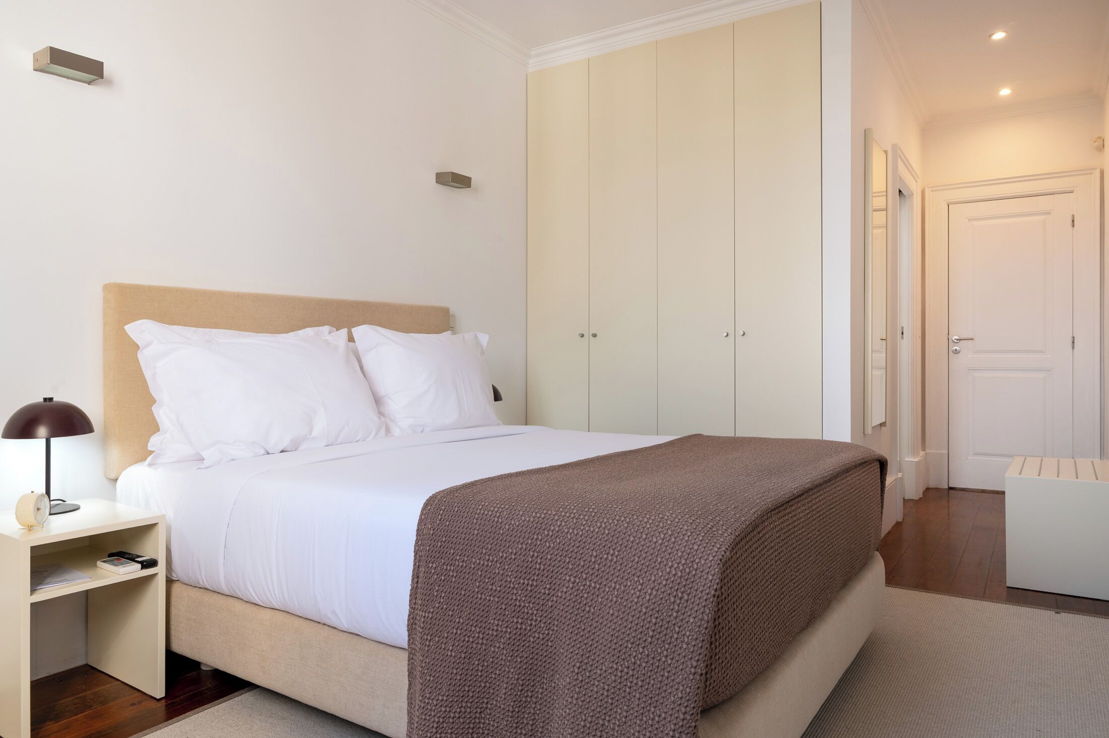 Ein ordentlich eingerichtetes Schlafzimmer mit Bett, Nachttisch und Kleiderschrank.