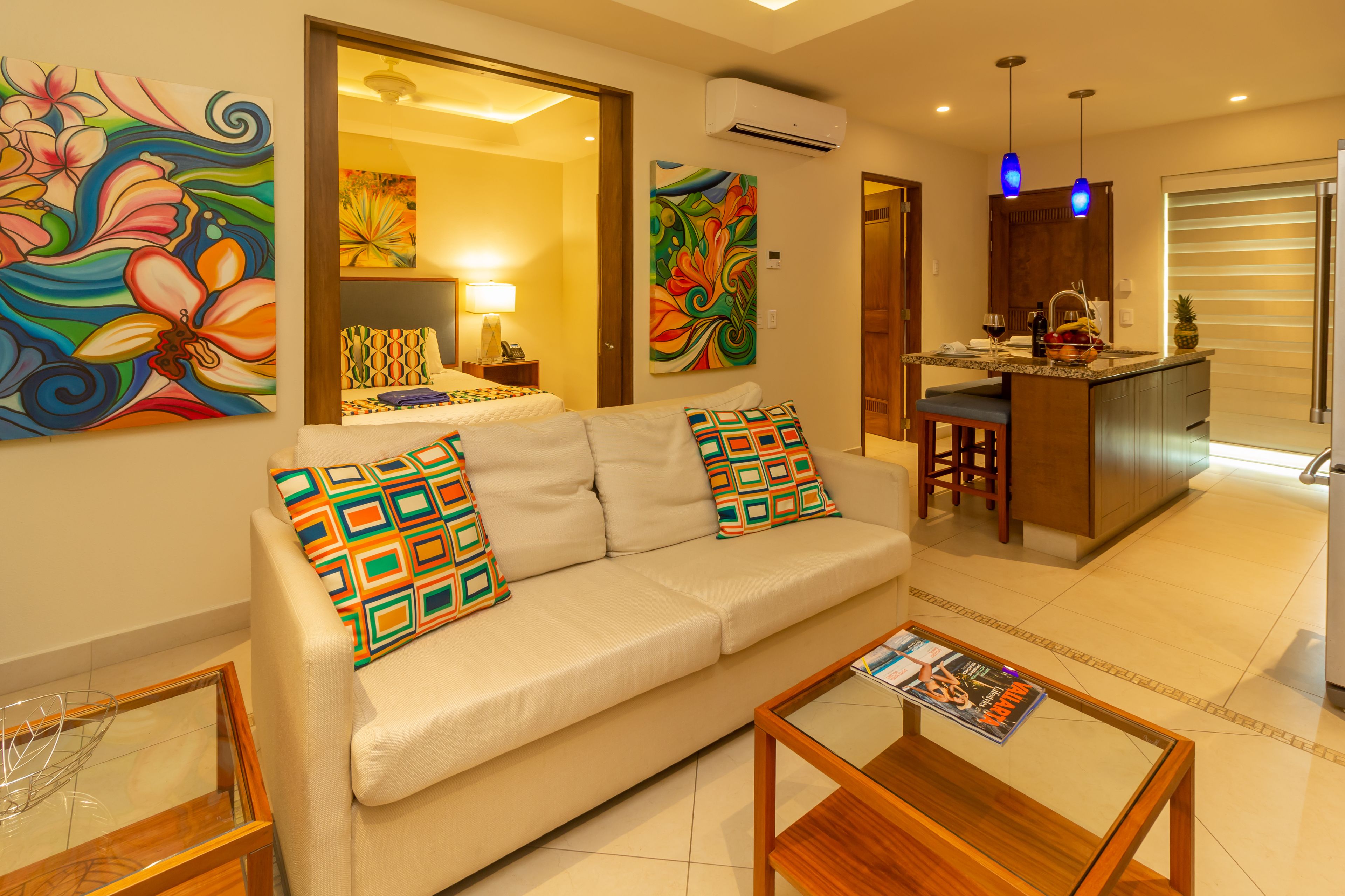 A modern living room with a sofa, coffee table, and artwork on the walls.