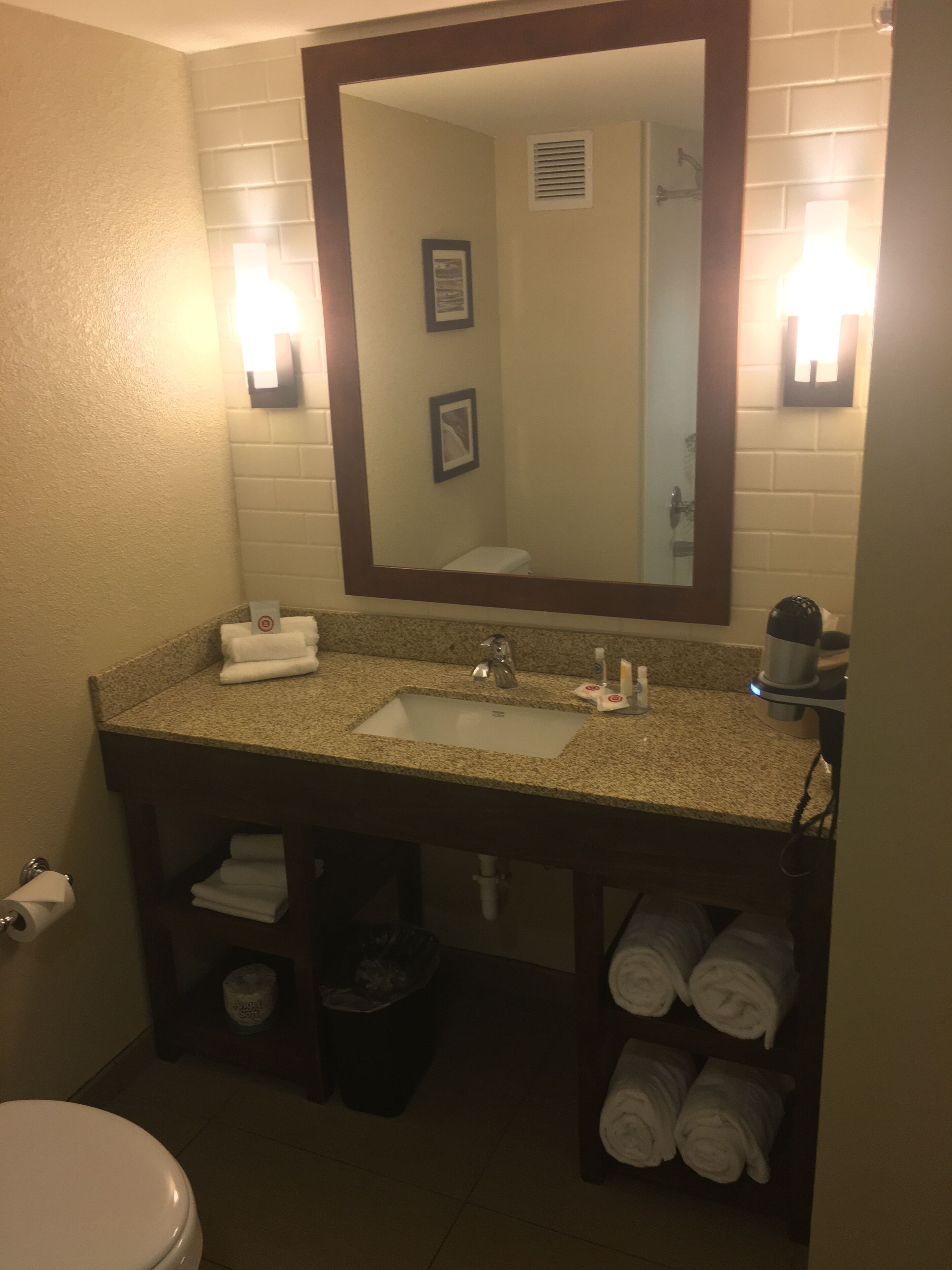 A bathroom with a sink, mirror, towel rack, and toilet.