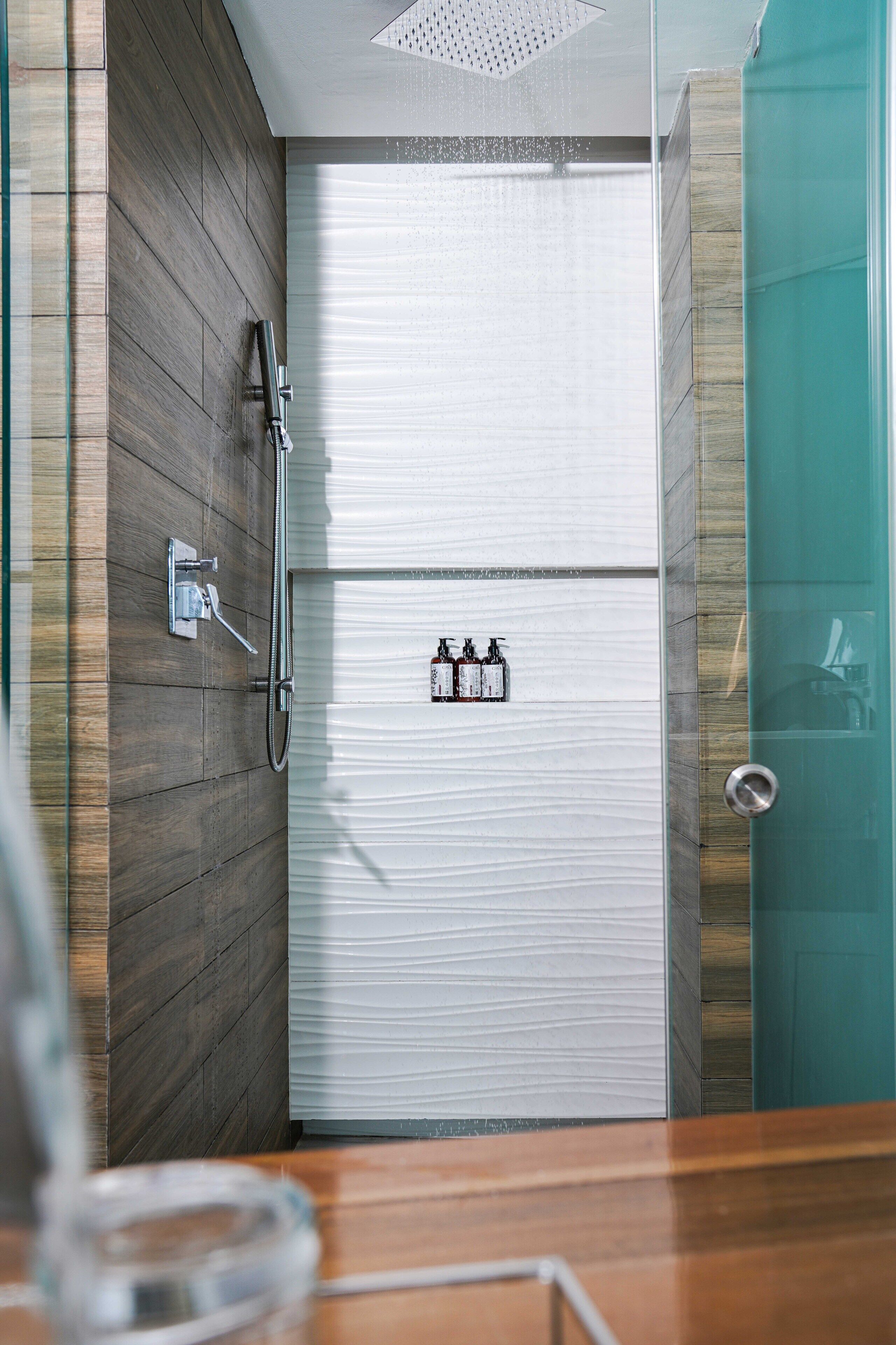 Une salle de bain moderne avec une douche, une porte en verre et un meuble-lavabo en bois.