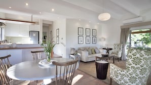 Een moderne woonkamer met een eethoek, een bank en een salontafel.