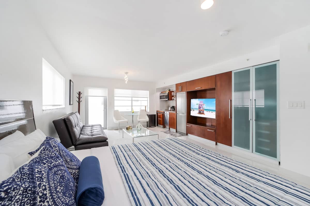 Un appartement moderne doté d’un grand lit, d’un canapé, d’un coin repas et d’une cuisine.