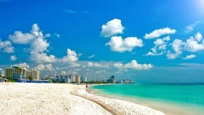 A beach with a clear sky and buildings in the background. - Strand Ocean Drive Suites (Miami Beach)