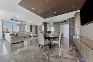 A modern living room with a dining area, a sofa set, and a TV. - Sian Oceanfront Condos (Hollywood)