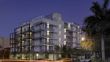 A multi-story hotel with a modern design, featuring balconies and large windows.