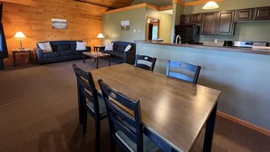 A cozy interior with a dining area, two sofas, a kitchen, and a ceiling fan. - Bluff Point Golf Resort (Plattsburgh)