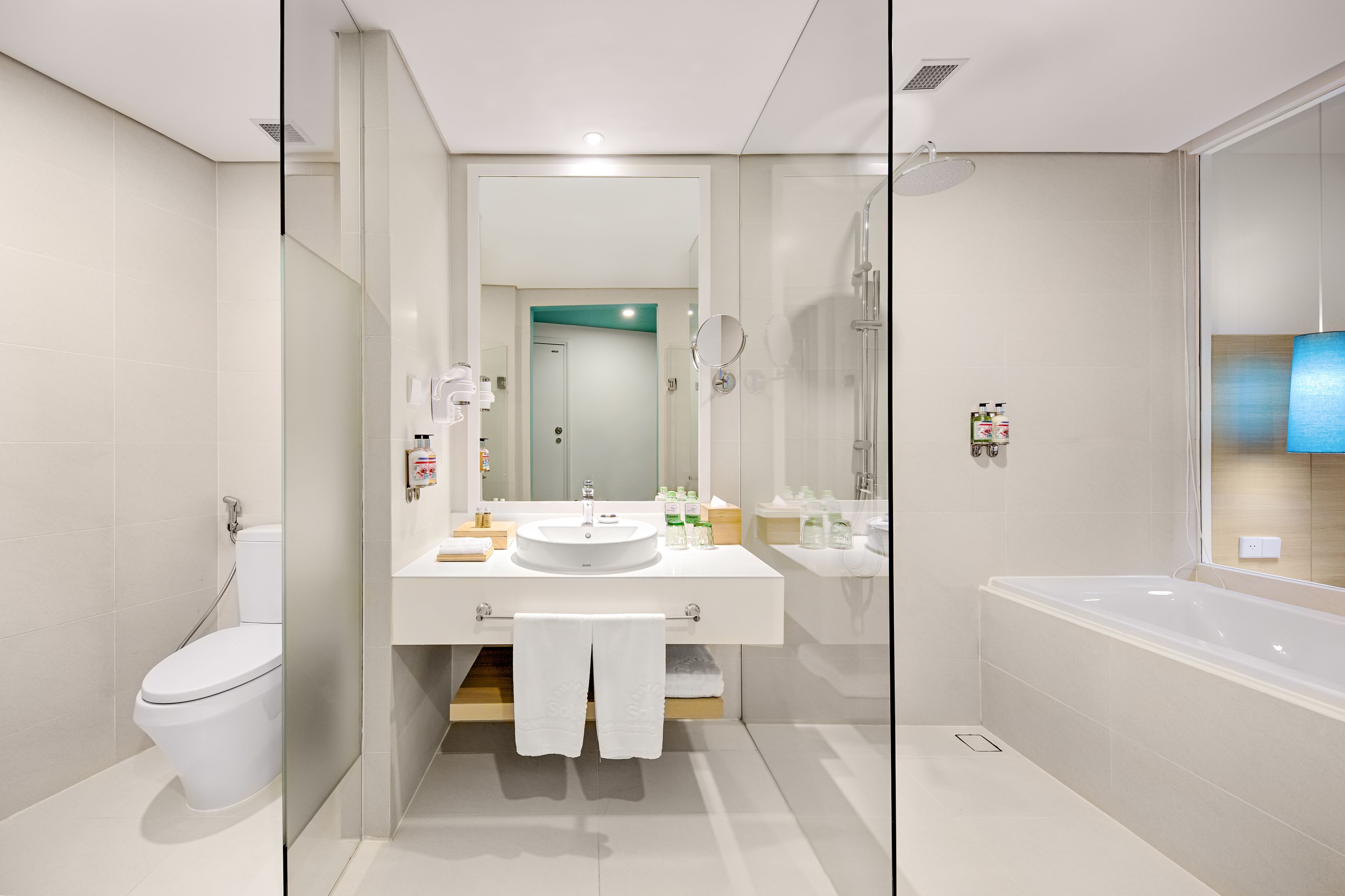 A modern bathroom with a glass-enclosed shower, a white sink, and a bathtub.