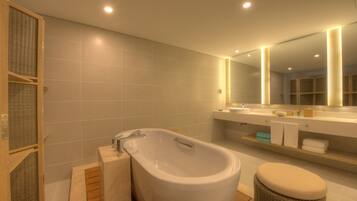 A modern bathroom with a freestanding bathtub, a large mirror, and a wooden vanity.