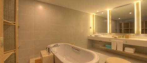 A modern bathroom with a freestanding bathtub, a large mirror, and a wooden vanity.