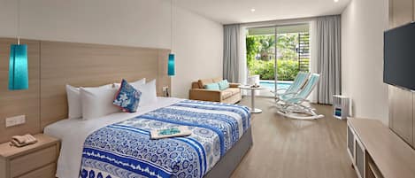 Una habitación de hotel moderna con una cama grande, un área de descanso con vista a la piscina y un televisor de pantalla plana.