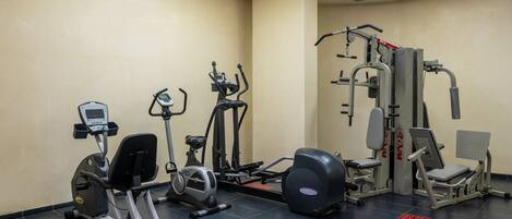 A gym with various exercise equipment, including treadmills, stationary bikes, and weight machines.