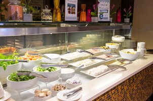 A buffet with various food items and utensils.