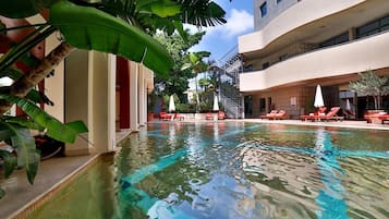 Una piscina al aire libre de temporada, sombrillas