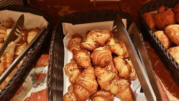 A buffet with baskets of croissants and cheese croissants.