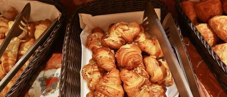A buffet with baskets of croissants and cheese croissants.