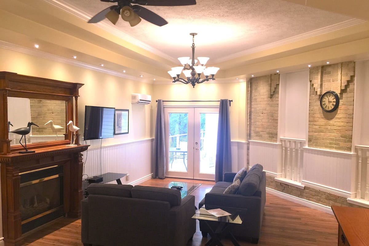 A living room with a fireplace, two sofas, a coffee table, and a television.