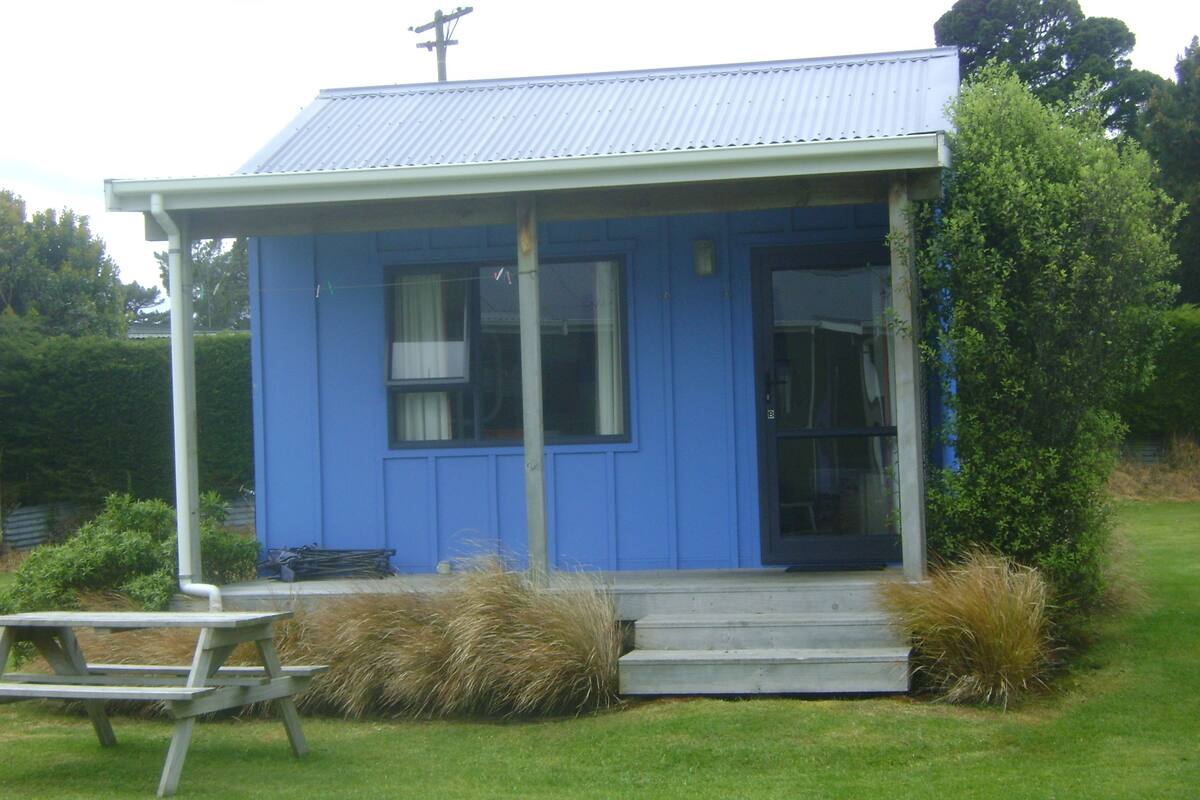 Il s’agit d’un petit bâtiment d’un seul étage, à l’extérieur bleu et doté d’un toit en métal. On y trouve une porte d’entrée, une fenêtre et un petit porche.