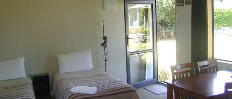 A hotel room with two beds, a desk, and a chair.