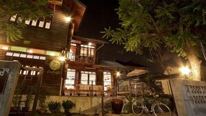 A two-story wooden building with balconies and a bicycle parked outside. - Baan Chang Ton (Surin)