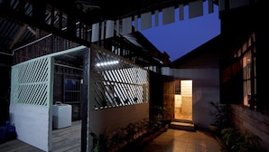 A modern building with a wooden deck, a covered outdoor area, and a well-lit entrance. - Baan Chang Ton (Surin)