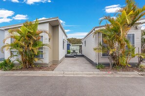 A row of mobile homes with a concrete pathway leading to a picnic table.