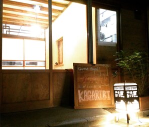 A wooden-framed window with a sign reading "Guest House" and "Welcome to KAGARIBI". - Kagaribi Guesthouse - Hostel (Tokyo)