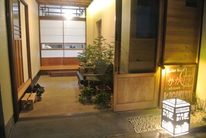 A traditional Japanese inn with a wooden exterior, a reception desk, and a sign welcoming guests. - Kagaribi Guesthouse - Hostel (Tokyo)