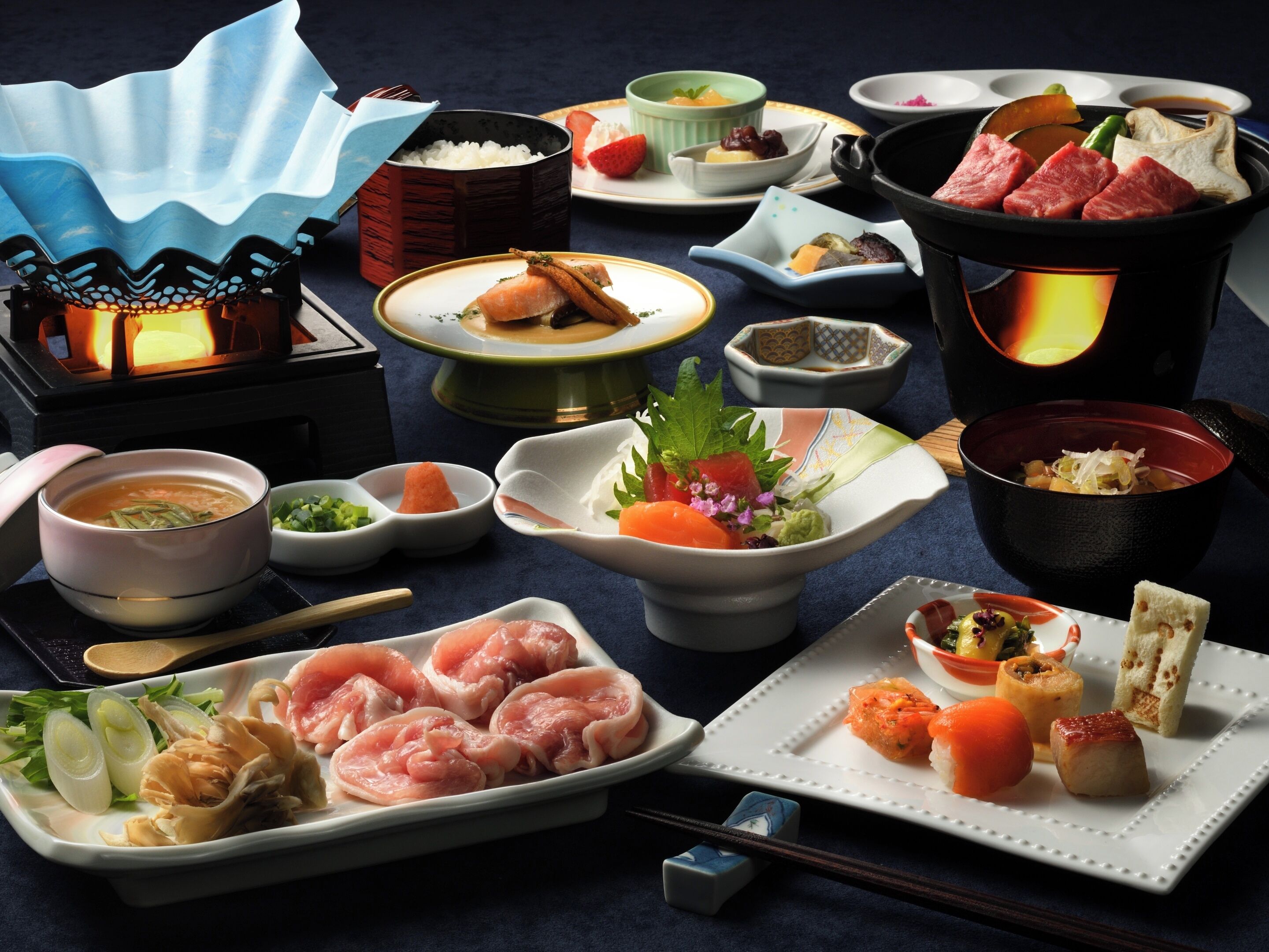 A variety of Japanese dishes, including sushi and sashimi, served on different plates and bowls.