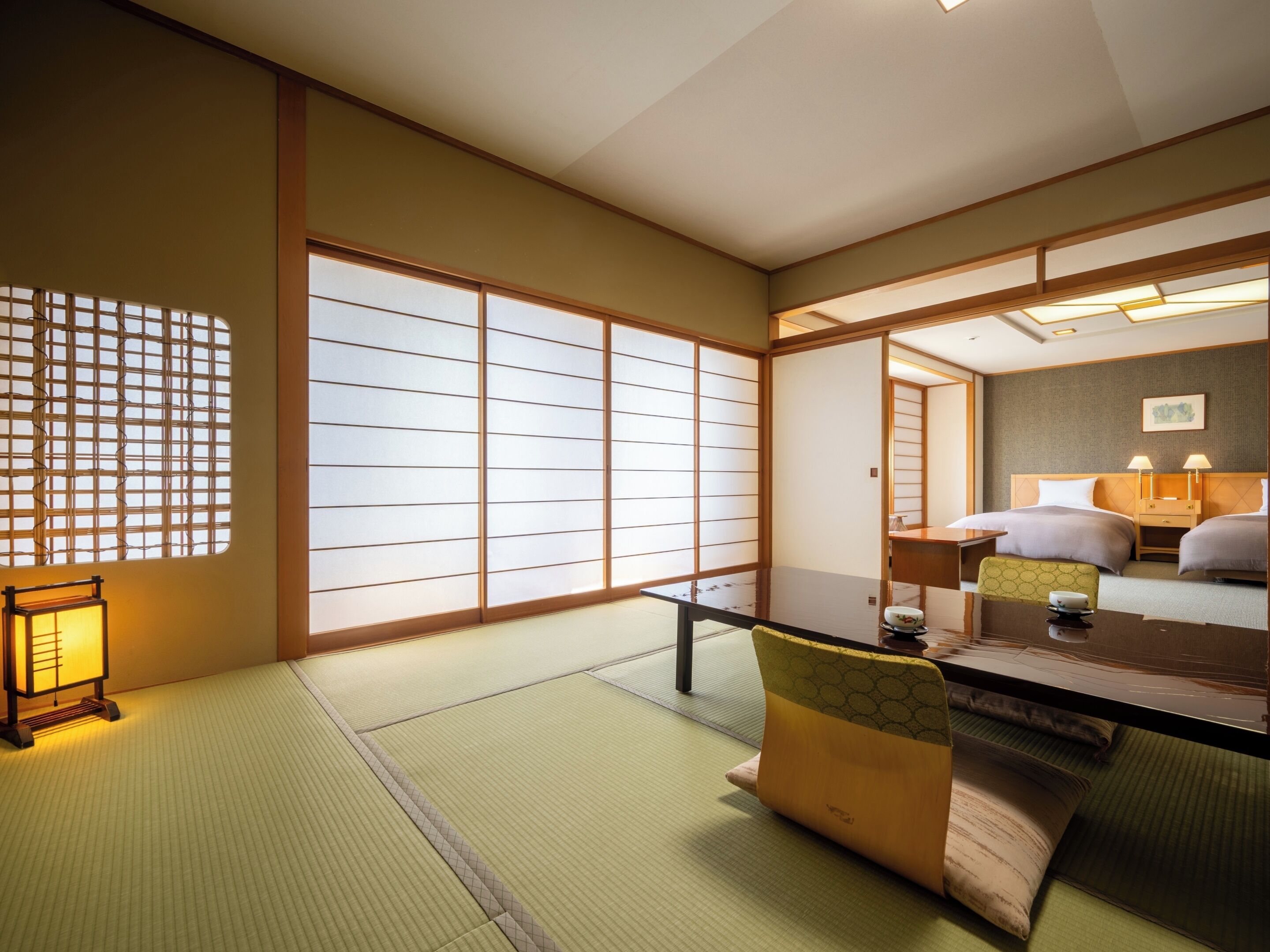 Ein traditioneller japanischer Raum mit Tatami-Boden, Shoji-Schirmwänden, einem niedrigen Tisch und einem Futon.