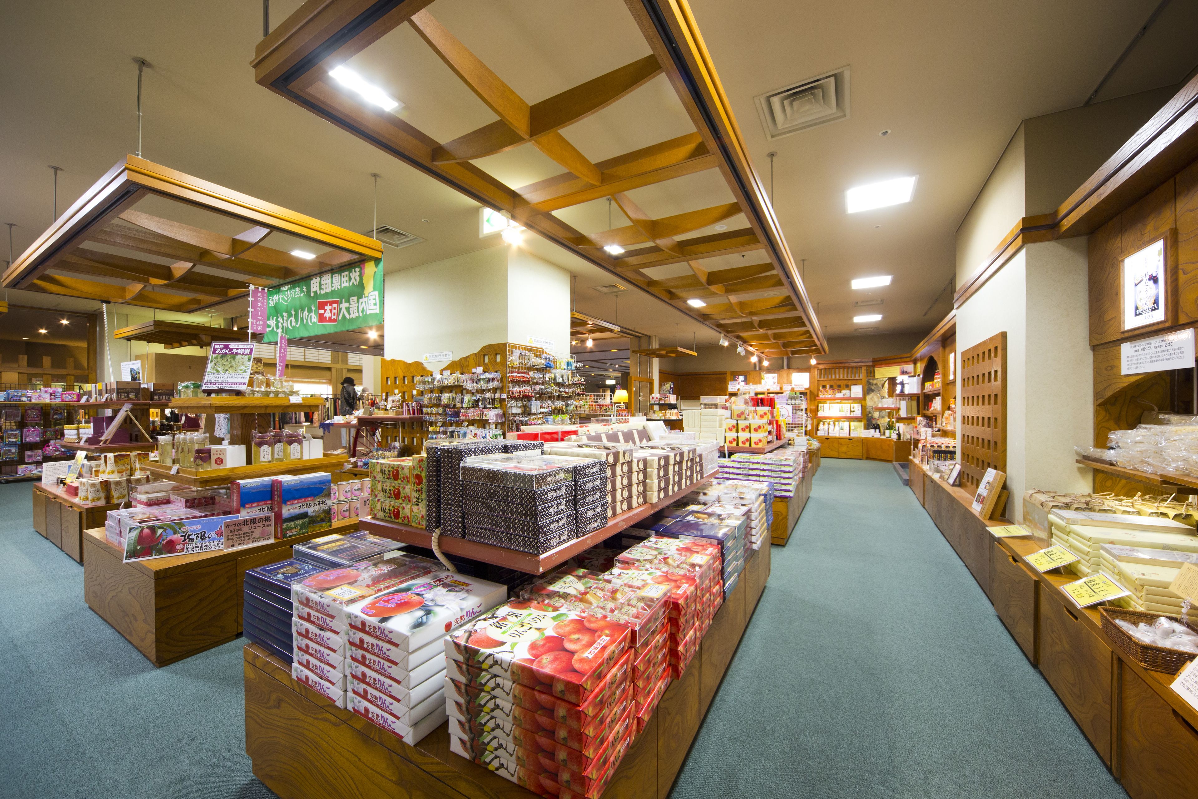 A spacious store with wide aisles and wooden display shelves.
