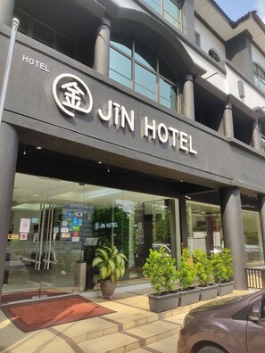 A hotel entrance with a modern design, featuring a prominent sign that reads "JIN HOTEL" and a logo above it. - JIN HOTEL (Puchong)