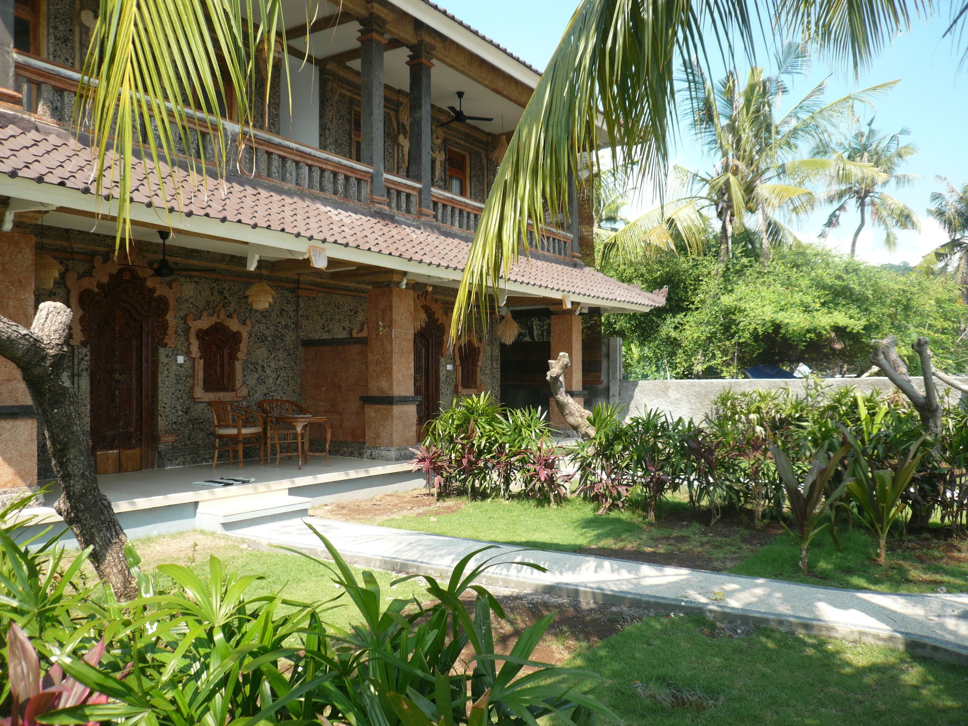 A traditional building with a tiled roof, a balcony, and a stone facade.