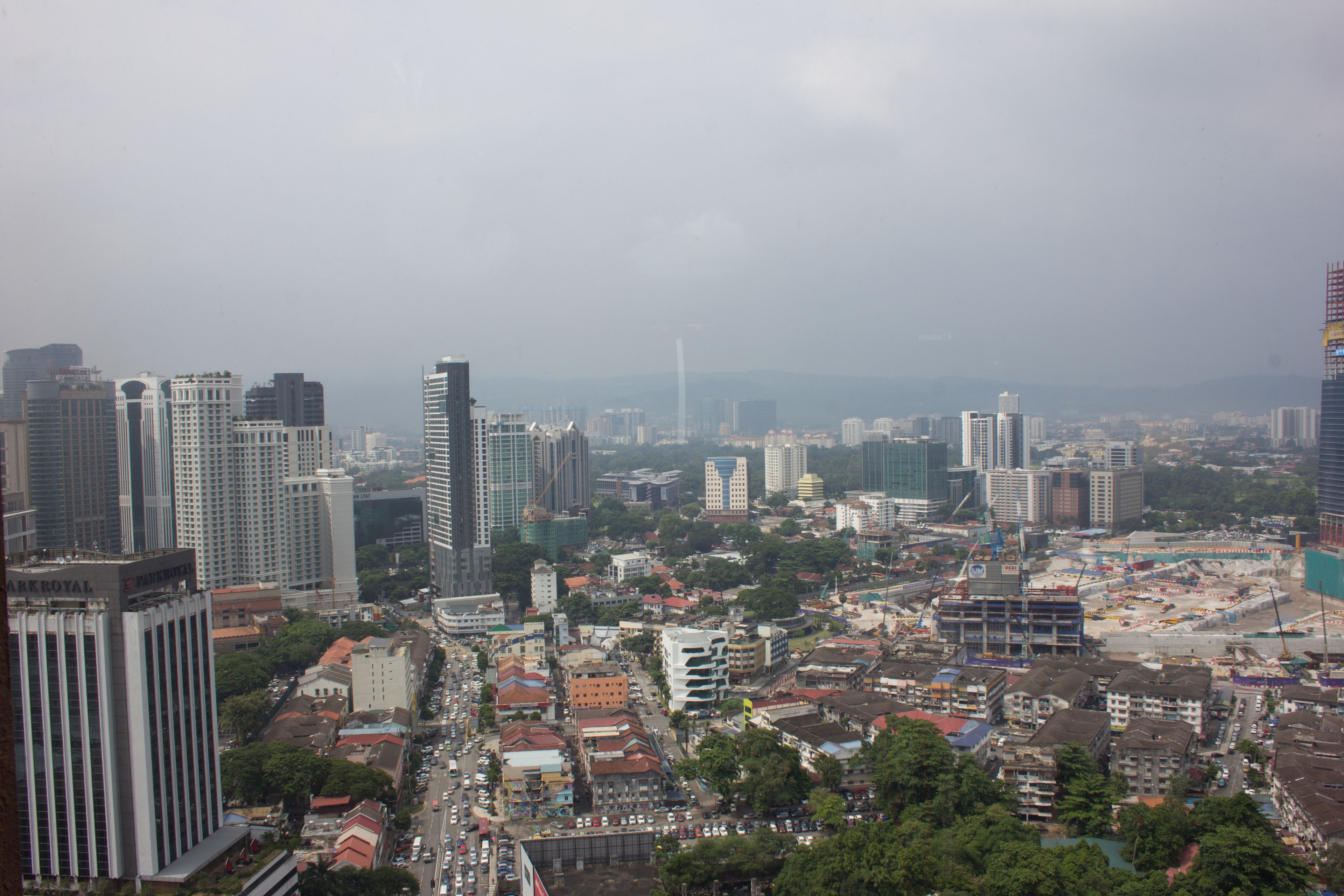 A cityscape with high-rise buildings, a mix of residential and commercial structures, and a construction site.