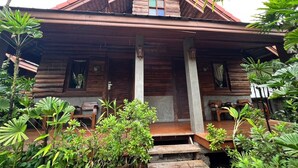 A wooden house with a sloped roof and a porch. - Yotaka Pai (Pai)