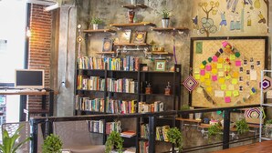 Una biblioteca acogedora con estanterías, una estación de café y un tablón de anuncios.