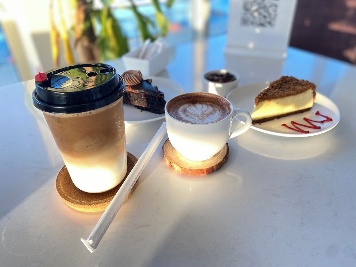 A table with a drink, a cup of coffee, and a slice of pie.