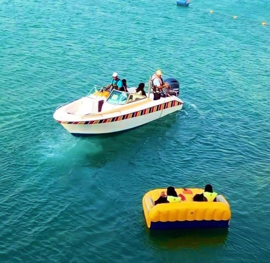 Ein Boot mit Passagieren und einer gelben Luftinsel im Wasser.