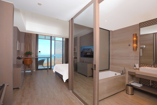 A modern hotel room with a large bed, a sitting area with a view, a separate bathroom, and a small kitchenette. - Mangrove Tree Resort World Qingdao (Qingdao)