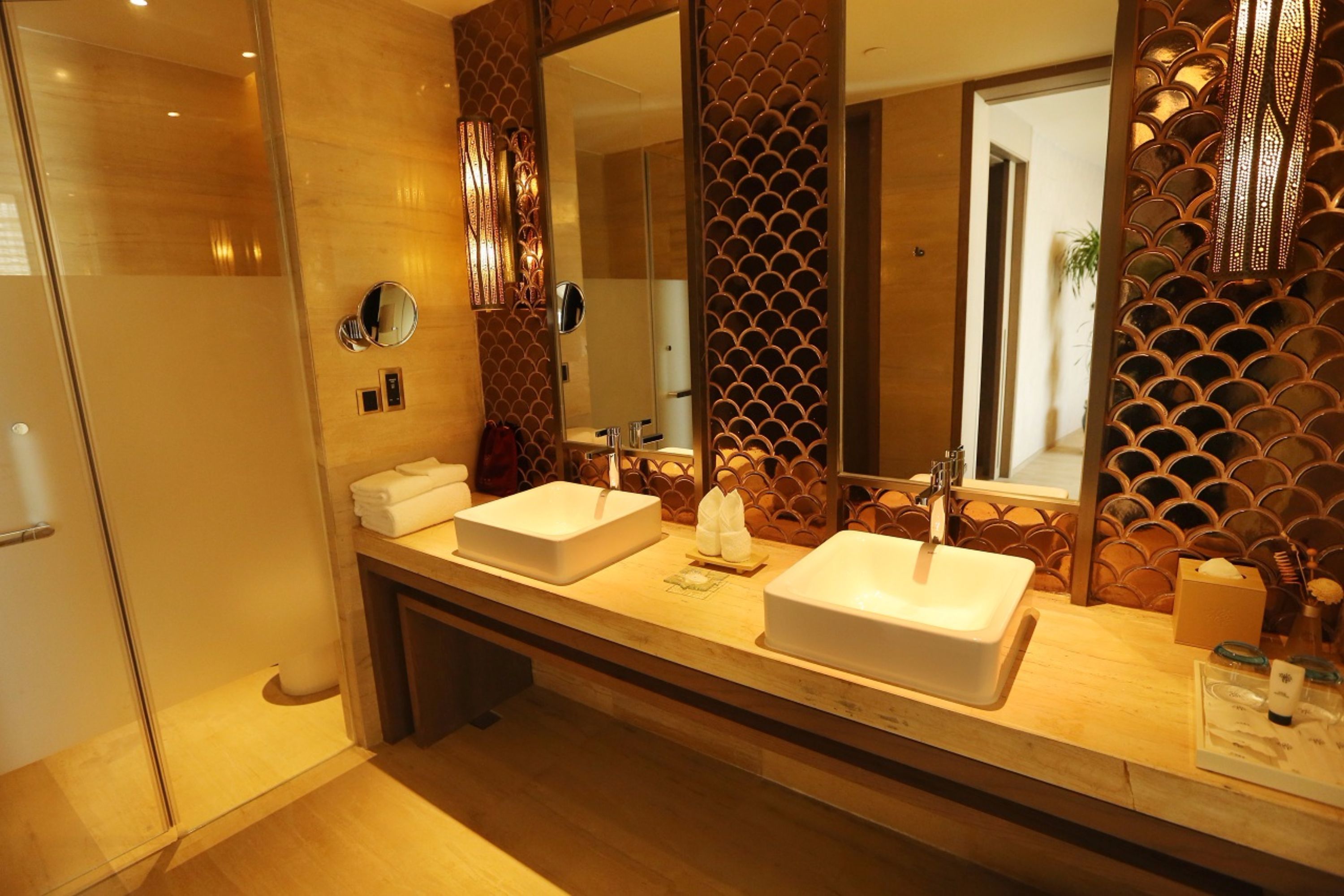 Une salle de bain moderne avec deux lavabos, un grand miroir et des panneaux décoratifs.
