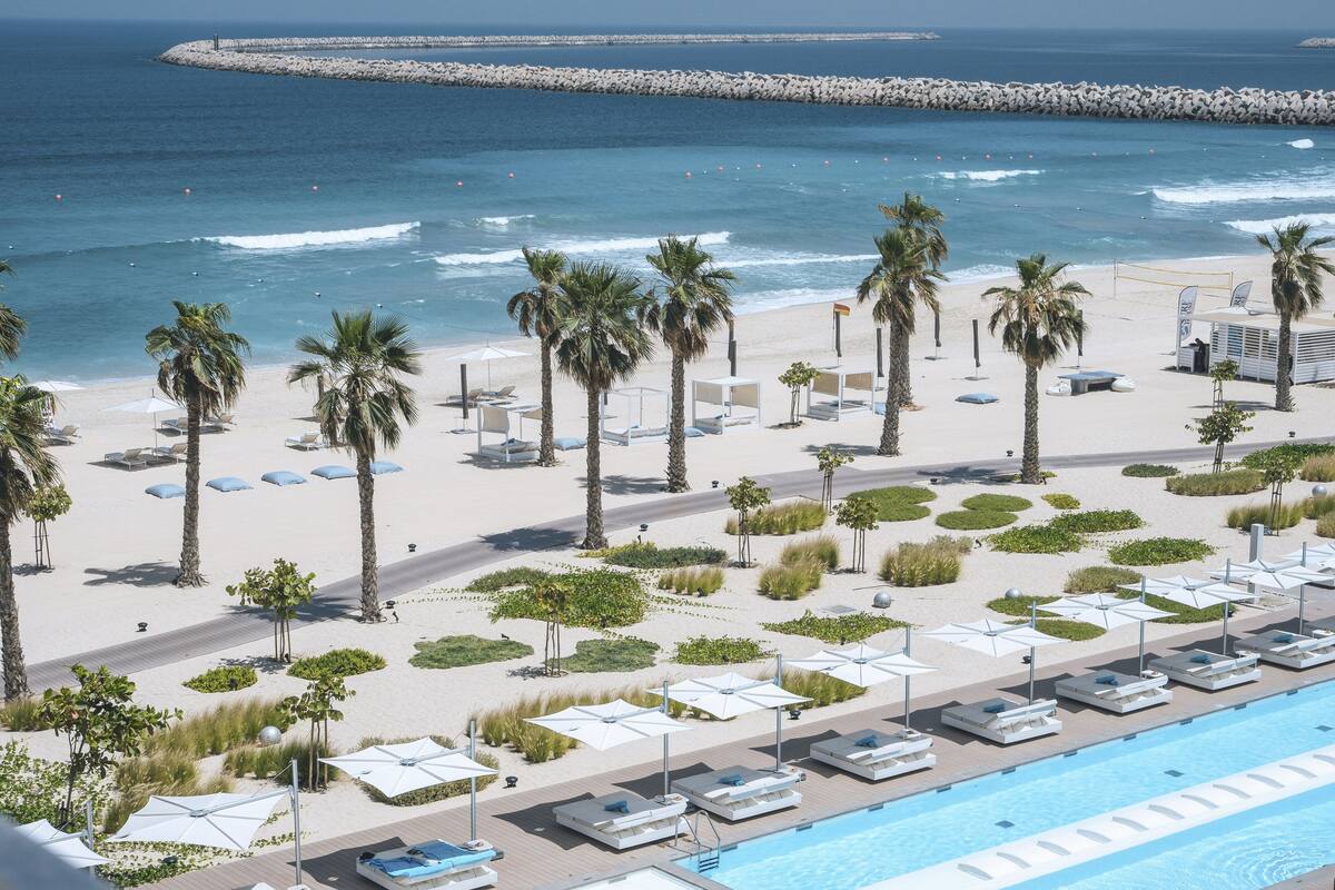 Een resort met zwembad, strand en uitzicht op zee.