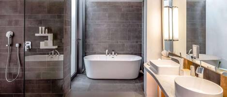 A modern bathroom with a freestanding bathtub, a glass-enclosed shower, and a vanity with a large mirror.